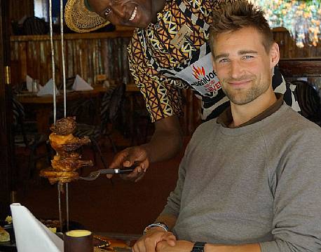 Vores rejseleder Nicolai fra Africa Tours får servert maden på Restaurant Carnivore, Nairobi, Kenya africa tours