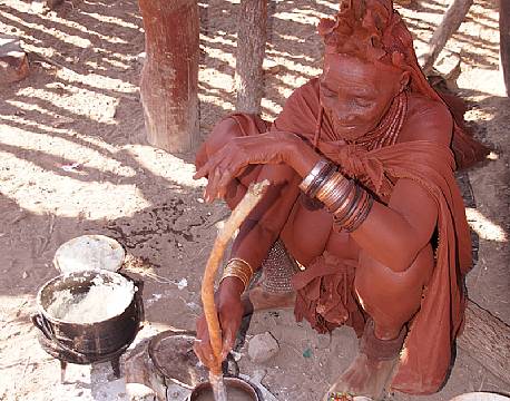 Himba kvinde laver mad, Namibia africa tours